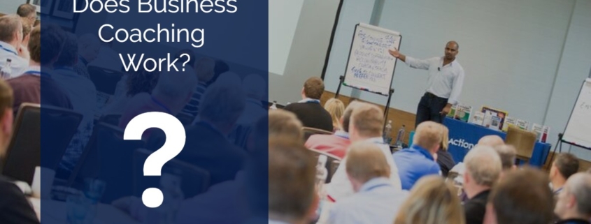 Photo of a room of people listening to a lecture of lesson, with an individual standing in front of a flipchart. In a red box are the words Does Business Coaching Work? (Infographic)