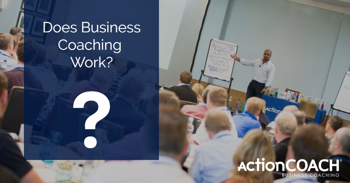 Photo of a room of people listening to a lecture of lesson, with an individual standing in front of a flipchart. In a red box are the words Does Business Coaching Work? (Infographic)
